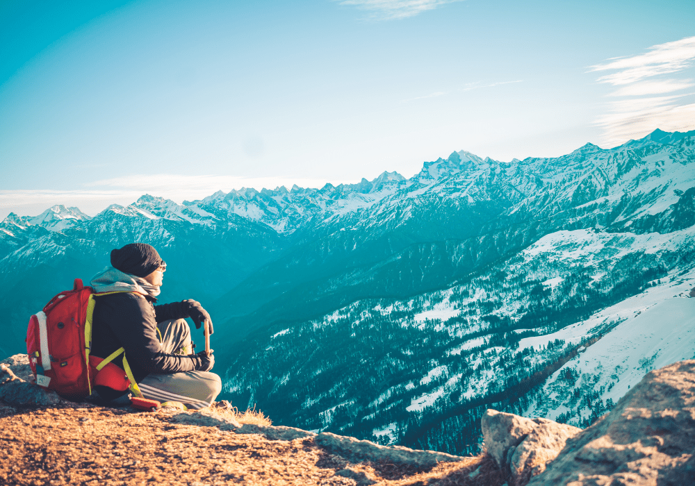 Person sitting on a snow-covered mountain in Manali