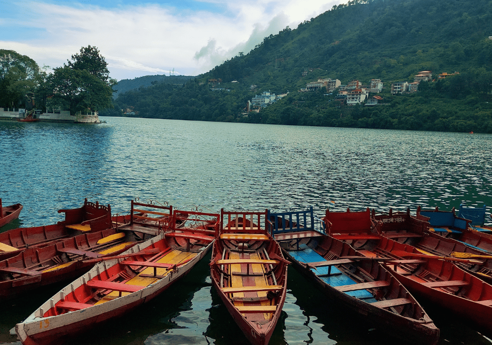 Boats lined up on the lake in Nainital with hills in the background