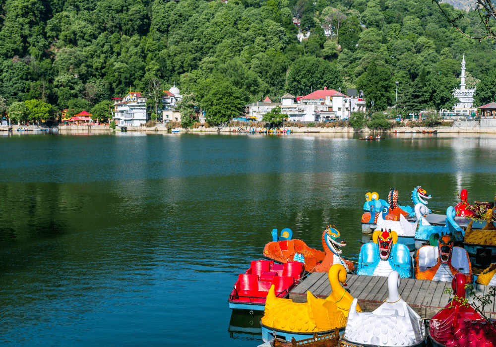 Boats floating on the river in Nainital surrounded by hills